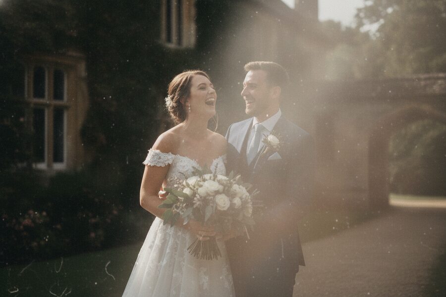 The same wedding photo shot through a smudged phone lens, hazy and washed out with a light flare
